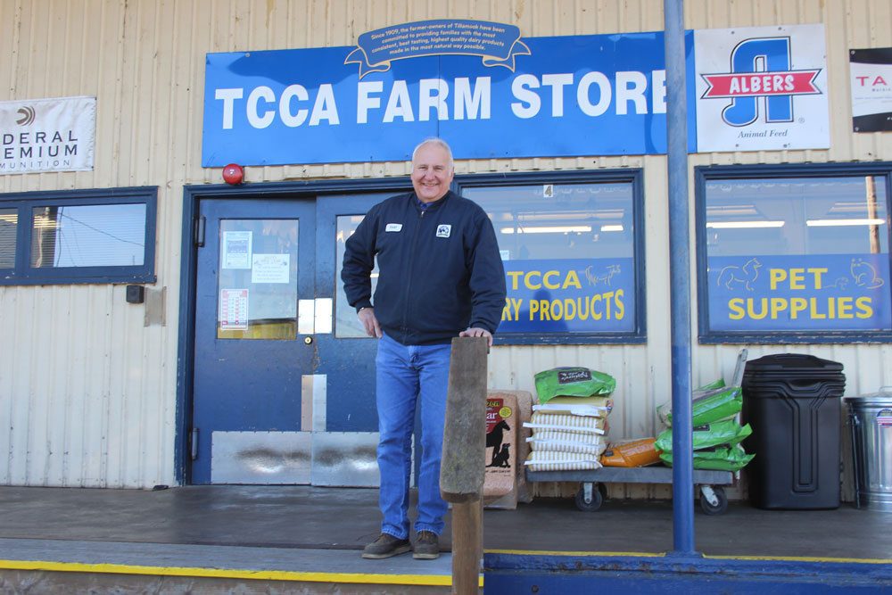 Man stands outside TCCA Farm Store sign